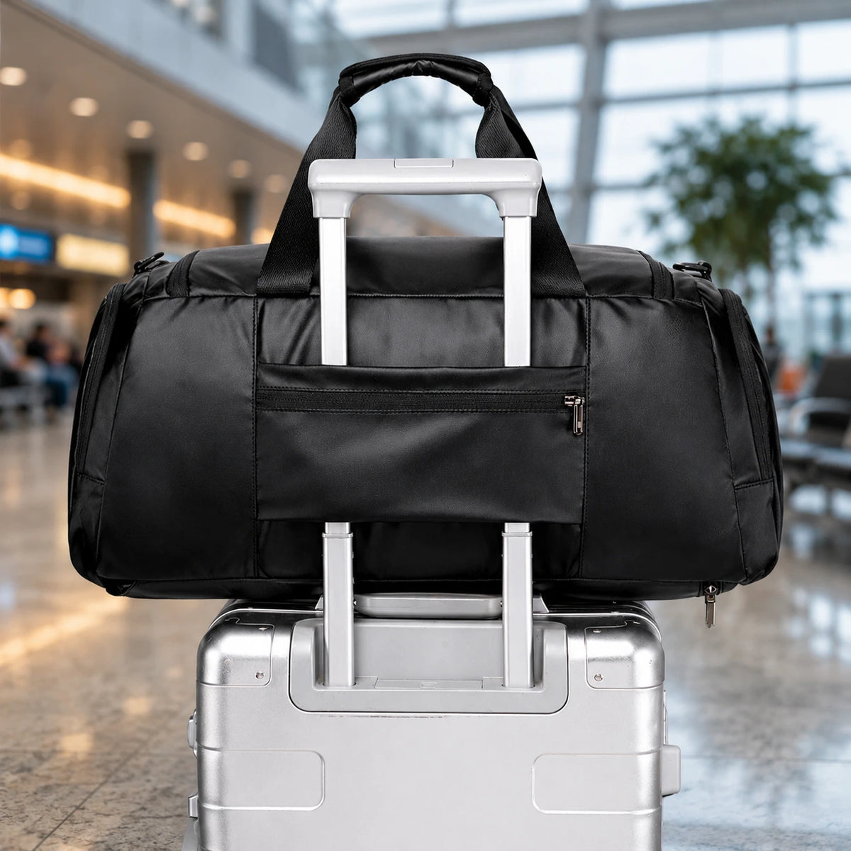 Sac de voyage ordinateur Le Voyage noir, clipsé sur une valise à roulettes