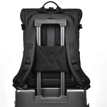 Sac à dos ordinateur Le Modulable noir, sangle porte bagage clipsée sur une valise à roulettes